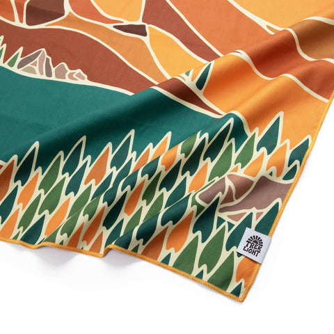 Alpenglow Wander Towel by Trek Light, made from recycled materials, featuring vibrant nature design. Lightweight, eco-friendly, quick dry.