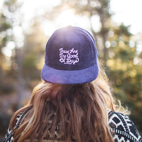 Person wearing a "These Are The Good Ol' Days" hat by Trek Light, enjoying a nostalgic outdoor moment. Happiness inspiring hats.