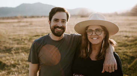 Couple enjoying a sunny day outdoors with mountains in the background, highlighting adventure and Trek Light lifestyle.