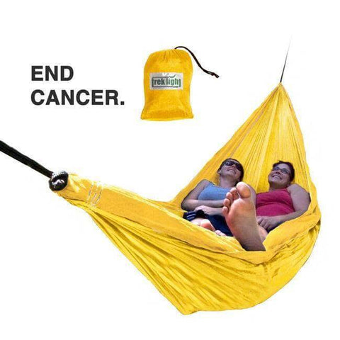 Two people relaxing in a yellow Trek Light hammock with 'End Cancer' message, promoting the Banana Hammock Bundle.