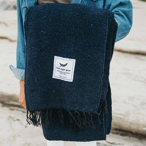 Person holding navy Newport Blanket by Trek Light Gear, ideal for Newport Jazz and Folk Festivals in Rhode Island.