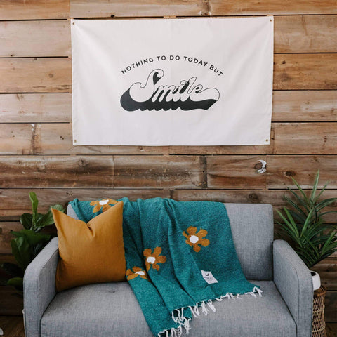 Trek Light Canvas Flag "Nothing To Do Today But Smile" hand-screened, sewn in USA, hanging on wooden wall above cozy couch.