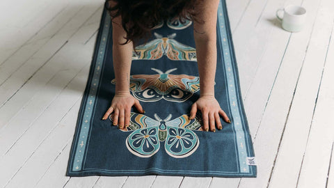Person doing yoga pose on Trek Light yoga towel with butterfly design, Grip-Tex fabric ensures stability and comfort.