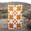 Goldie Blanket handwoven geometric beauty made from recycled clothing materials, cozy and versatile in natural setting. By Trek Light.