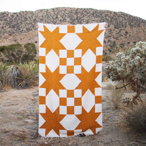 Goldie Blanket handwoven geometric beauty made from recycled clothing materials, cozy and versatile in natural setting. By Trek Light.