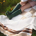 Cozy handwoven North Star blanket made from recycled clothing, showcasing beautiful natural tones. Perfect for outdoor relaxation. By Trek Light.
