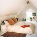 Cozy bedroom with a Red Rocks Blanket, handwoven from recycled clothing, adding a beautiful, versatile touch to a serene setting.