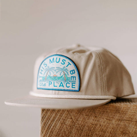 Trek Light's "This Must Be The Place" beach hat, unisex 6-panel snapback with flat brim and breathable vent holes, perfect for sunny adventures.