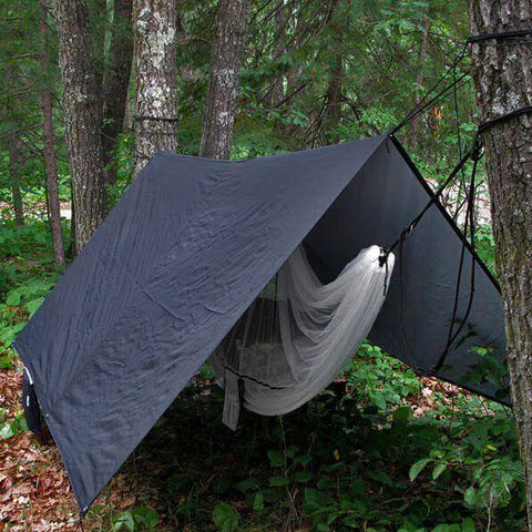 Trek Light V9 Strong Tarp covering hammock in forest setting, perfect rain fly for outdoor adventures.