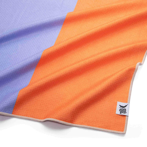 Trek Light Divided Sky Yoga Towel in orange and purple with sustainable Grip-Tex™ fabric, portable and eco-friendly.