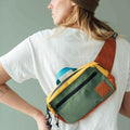 Person wearing Cypress Everyday Fanny Pack by Trek Light as a stylish shoulder sling, showcasing colorful design and pocket perfection.