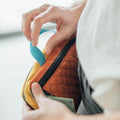 Person adjusting the Trek Light Everyday Fanny Pack in Cypress, showing the quilted design and versatile strap for hip or shoulder wear.