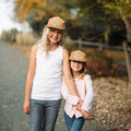 Kids wearing Go Outdoors Trek Light corduroy hats on a sunny day, smiling together on a path surrounded by nature.
