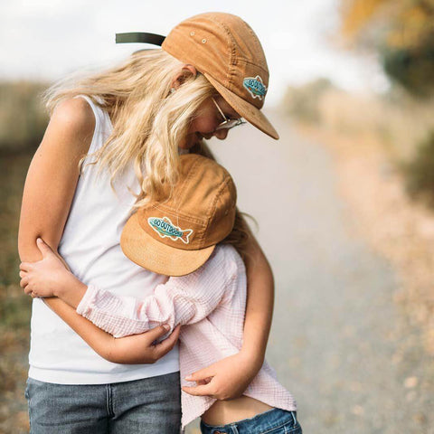 Kids in Trek Light Go Outdoors Corduroy Hats hugging, perfect for outdoor adventures. Eco-friendly style.