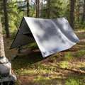 V9 Strong Tarp by Trek Light set up in the woods as a hammock rain fly, providing durable shelter for outdoor camping adventures.