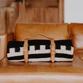 Handmade artisan Trek Light leather blanket carrier with a stylish design on a cozy couch.