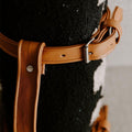 Close-up of Trek Light's artisan-crafted leather blanket carrier, elegantly wrapped around a cozy blanket. Stylish outdoor accessory.