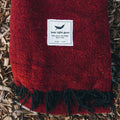 Cozy Trek Light Napa Blanket with rich red hue, made from recycled materials and handwoven for unique quality.