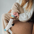 Person relaxing in cozy Trek Light Stay Wild socks with perfect stretch and cushion, embodying playful comfort and style.